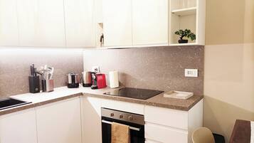 Fridge, coffee/tea maker, cookware/dishes/utensils, dining tables