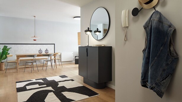 A modern living room with a dining area, a black cabinet, a mirror, a telephone, and a denim jacket hanging on the wall. - Negua by FeelFree Rentals (San Sebastian)