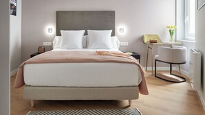 A modern bedroom with a large bed, bedside tables, a chair, and a window with a view. - Negua by FeelFree Rentals (San Sebastian)