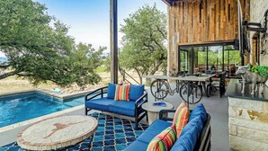 A poolside area with a blue sofa, a round table, and a bicycle.