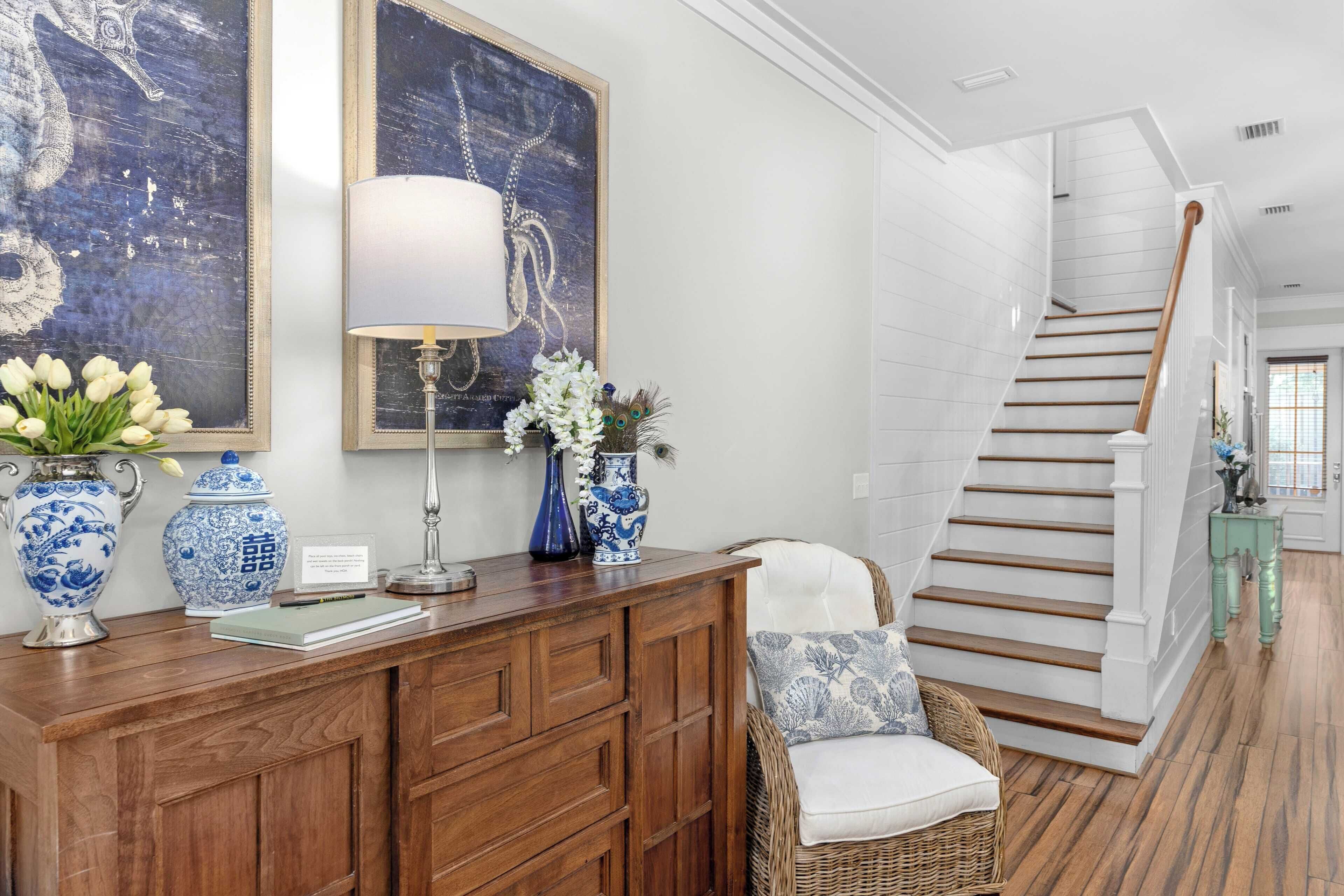 A wooden reception desk with blue and white vases, a lamp, and a chair with a cushion.