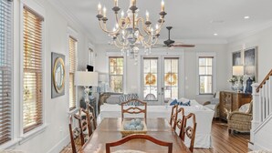 A spacious dining area with a chandelier, wooden dining table, and chairs. - Seagrove Gardens Mins to the Beach, Santa Rosa Retreat w/ A+ Design (Santa Rosa Beach)