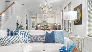 A white living room with a chandelier, a dining area, and a staircase. - Seagrove Gardens Mins to the Beach, Santa Rosa Retreat w/ A+ Design (Santa Rosa Beach)