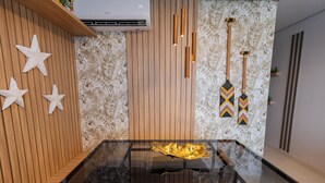Un interior moderno con una mesa de vidrio, paneles de madera y decoración de arte mural con forma de estrella.