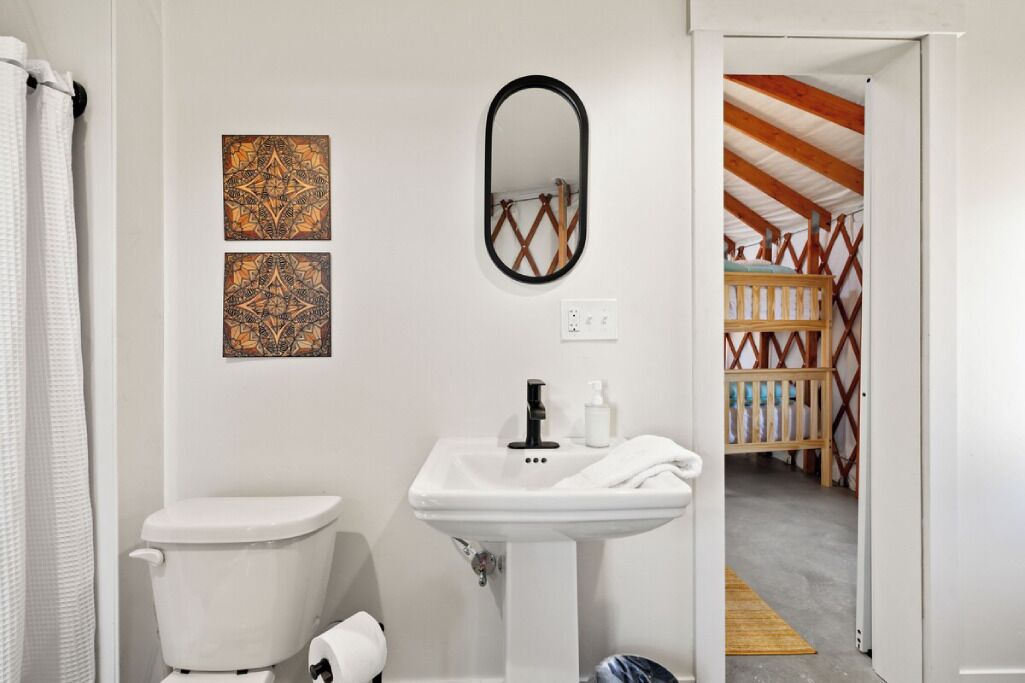 Un baño con inodoro, lavamanos y dos paneles decorativos en la pared.