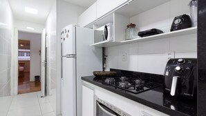 A modern kitchen with white cabinets, a black countertop, a built-in oven, a gas stove, and a coffee maker. - Refuge in Copacabana 5min From the Beach Nsc1102 (Rio de Janeiro)