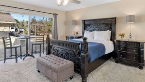A bedroom with a large bed, a ceiling fan, a nightstand, a dresser, and a dining area with chairs and a table. - Bordeaux by Avantstay Private Pool, Hot Tub & Game Room Near Temecula (Temecula)