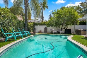 Relax in a serene, setting surrounded by lush greenery and a sparkling pool.