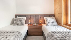 A double room with two beds, a wooden headboard, bedside lamps, and a window with wooden blinds. - Wonderful appt 6 ppl with balcony (Saint-Sorlin-d´Arves)