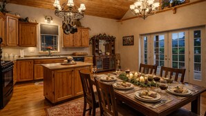 A cozy kitchen with wooden cabinets, a central island, and a dining area set for a meal.