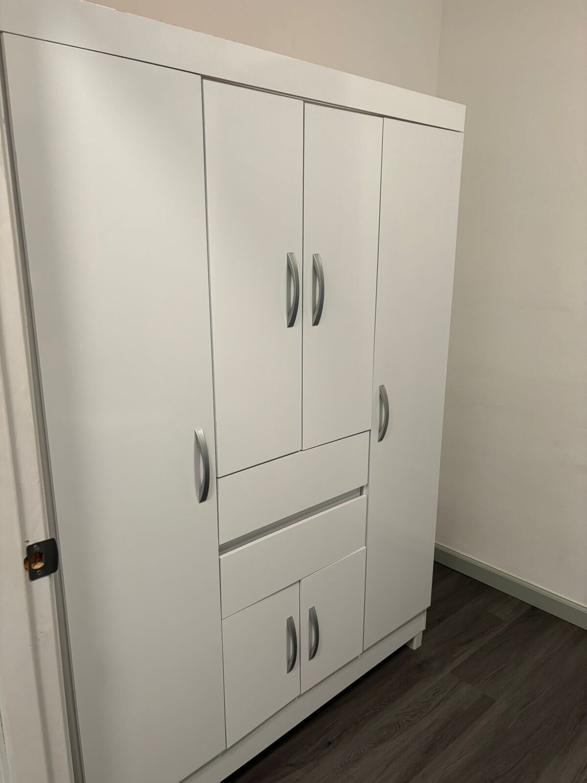A white wardrobe with two doors and two drawers, featuring silver handles.