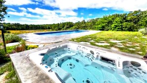 A hot tub with a view of a swimming pool and surrounding greenery. - Charming 6 bdr house-Chappaquiddick near Edgartown, beaches, 20x60pool,amenities (Edgartown)
