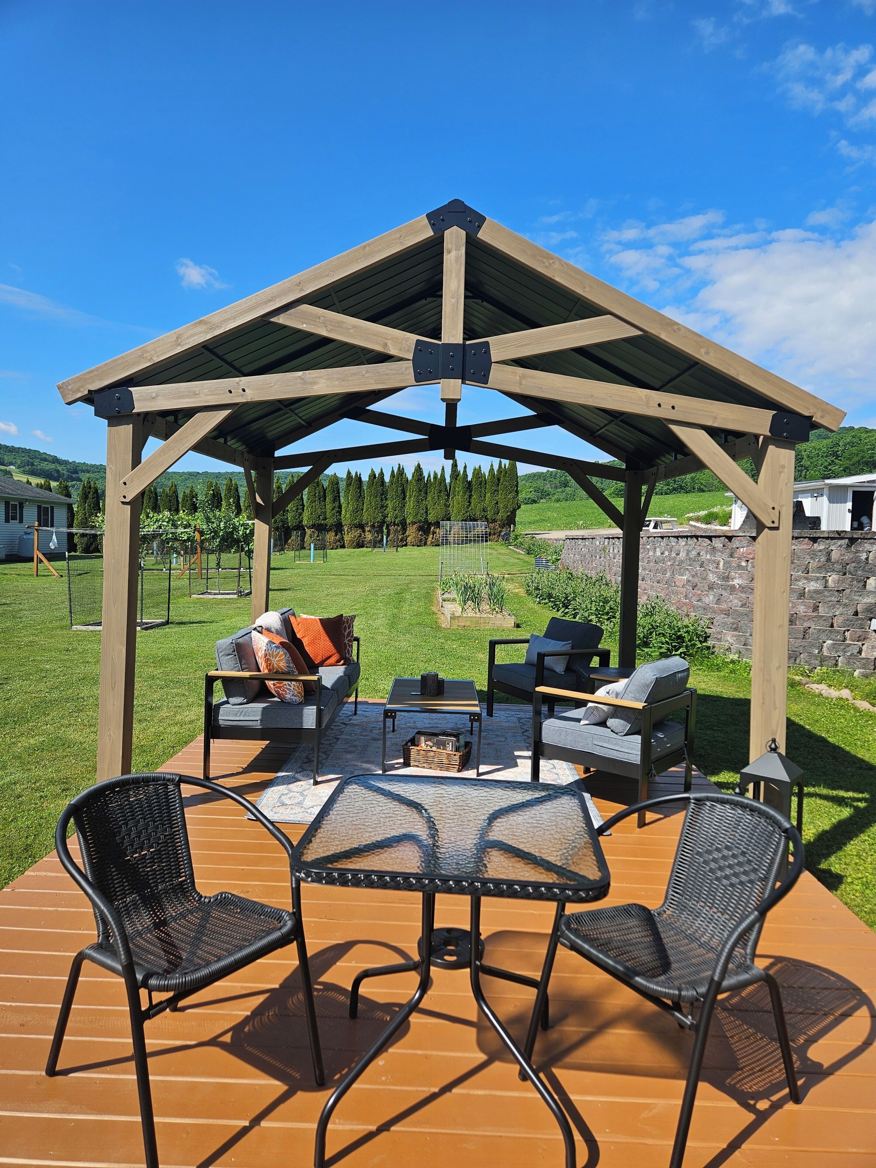 A wooden pergola with a fire pit and seating area.