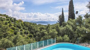 Une piscine offrant une vue dégagée sur le paysage environnant, notamment sur les arbres et les montagnes au loin.