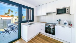 A modern kitchen with white cabinets, a built-in oven, and a microwave. - Villa Julaga (La Oliva)