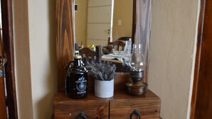 A wooden dresser with a mirror, a bottle, and a lamp. - Argentina, Mountain Lodge (El Calafate)