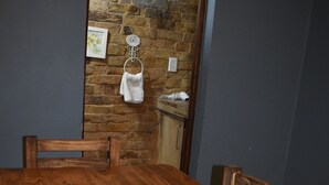 A wooden dining table with a crocheted placemat, a decorative bowl, and a book titled 'Doll's House'. - Argentina, Mountain Lodge (El Calafate)