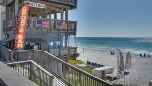 Eine Strandbar mit Holzkonstruktion, amerikanischen Flaggen und freiem Blick auf den Ozean.