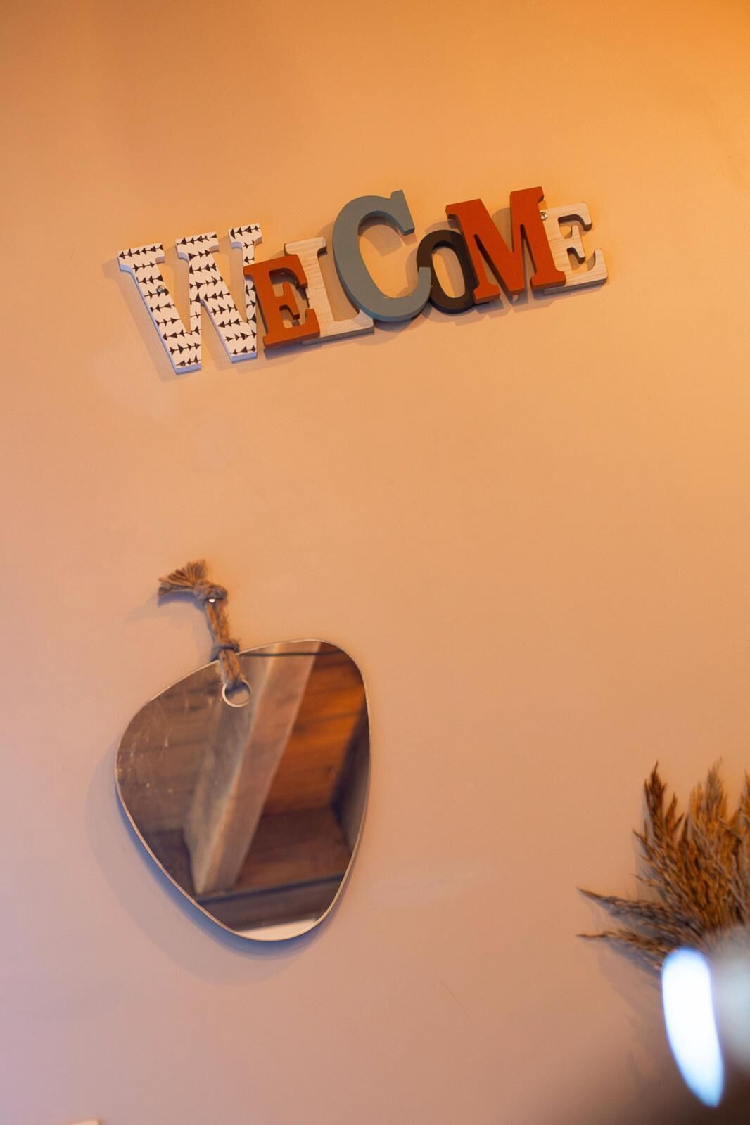 Een muur met een 'Welcome'-bord en een sleutelhanger.