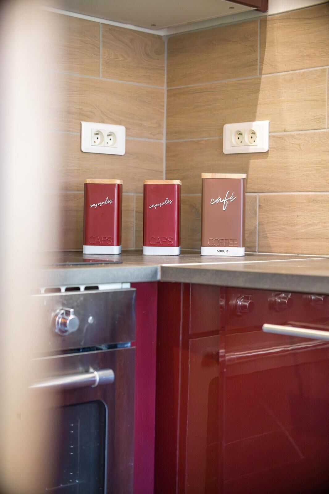 Une cuisine avec trois capsules de café sur le comptoir, une cuisinière et un four à micro-ondes.