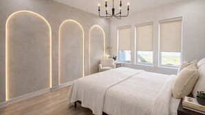 A modern bedroom with a large bed, a chandelier, and three illuminated wall panels. - Downtown Dallas Home  (Dallas)