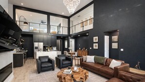 A modern living room with a brown leather sofa, black leather armchairs, and a wooden coffee table. - Downtown Dallas Home  (Dallas)