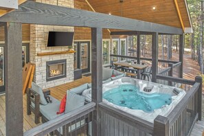 Une terrasse dotée d’un jacuzzi, d’un espace salon et d’une cheminée.