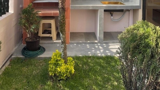 A modern outdoor kitchen with a built-in sink and a small seating area. - Suite 1 habitación full amoblada (Cuenca)