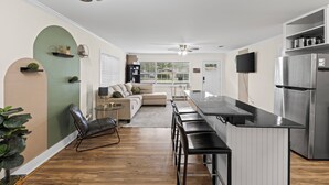 Une cuisine moderne avec un coin bar, un canapé et une table à manger.
