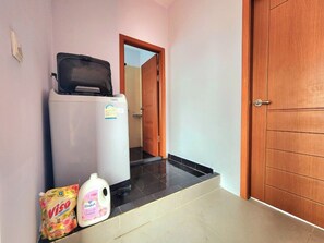 A hallway with a white refrigerator, a bottle of Viso, and a bottle of Comfort Plus. - Bright 2BR House • Central Phnom Penh • Sleeps 4 • Workspace • Laundry (Phnom Penh)