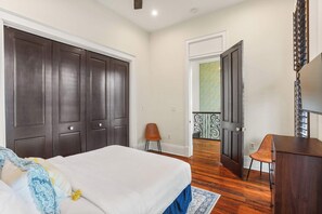 Une chambre à coucher avec un grand lit, une armoire en bois foncé, un bureau et une chaise.