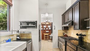 Une cuisine moderne dotée d’un îlot central, d’appareils électroménagers intégrés et donnant sur l’espace repas.