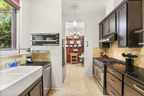 Una cocina moderna con una isla central, electrodomésticos integrados y vistas al comedor.