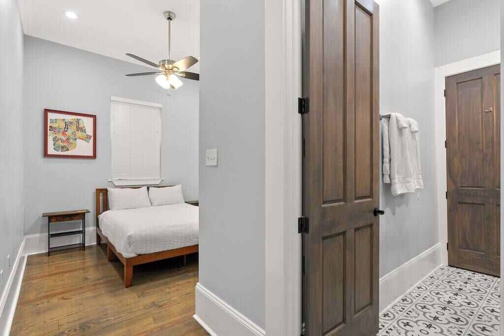Queen room features comfortable bedding, closet, and direct access to the shared bathroom with the twin bedroom. 