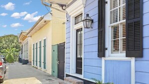 Una stretta via fiancheggiata da edifici colorati, con un'auto parcheggiata e un cielo sereno.