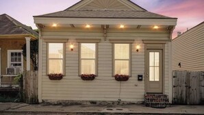 Eenlaags huis met een puntgevel, een veranda met een hekwerk en een kleine voortuin.