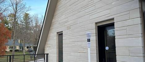 Un edificio moderno con techo inclinado, una ventana pequeña y una puerta.