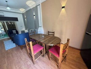 Enjoy meals in this cozy dining area with a wooden table and comfortable seating for four.