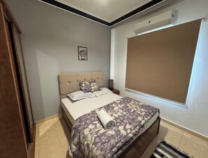 Relax in a cozy space with a comfortable bed, framed artwork, and a window with a view.