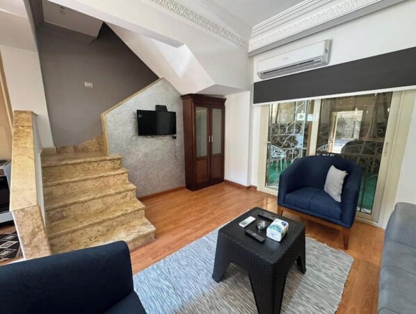 Relax in this stylish living space with a flat-screen TV and comfortable seating area.