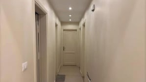 A narrow, well-lit hallway with plain walls and a door at the end. - 903 . Spacious 3BR Apt., 2 Baths, Gated Community (Al Sheikh Zayed)
