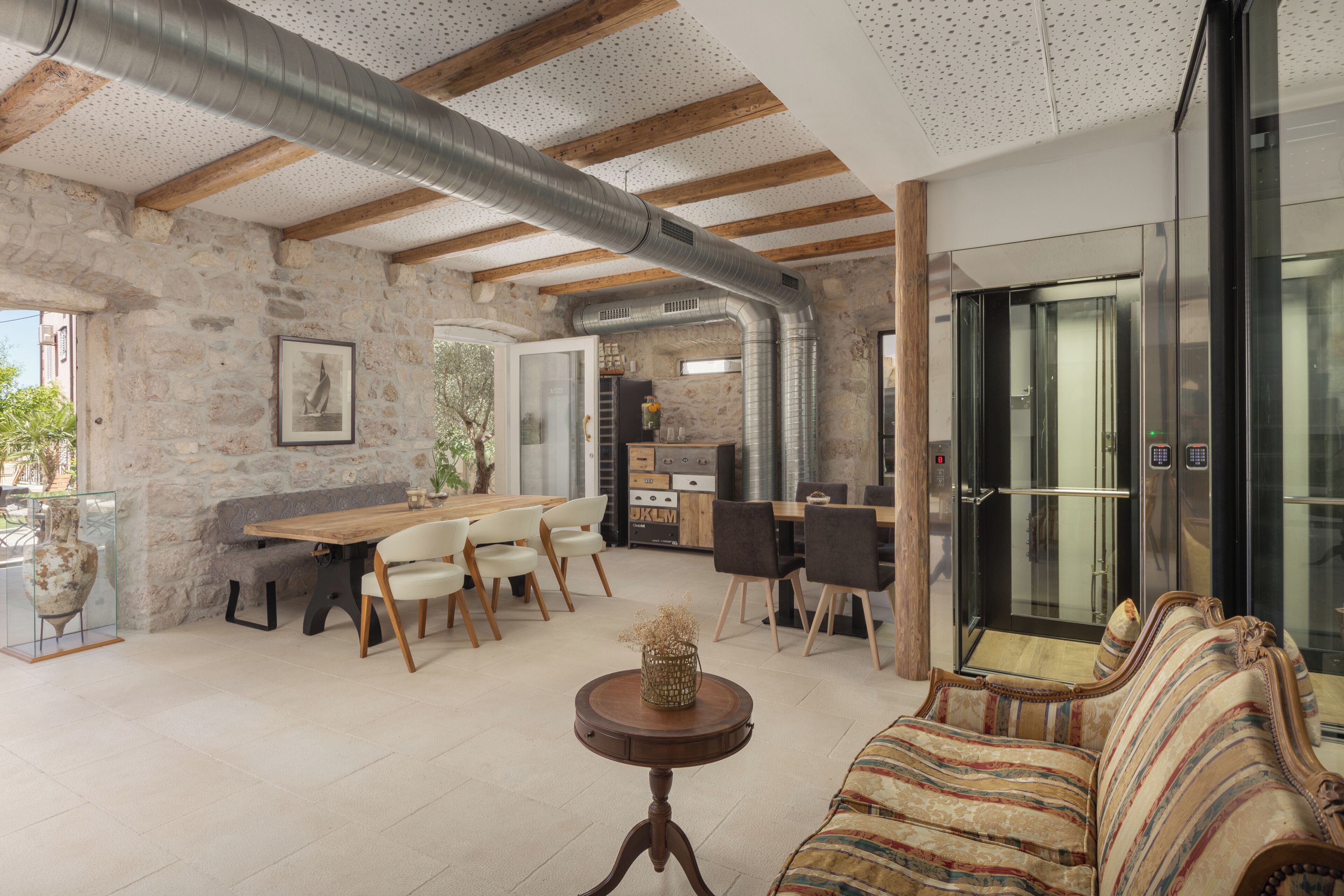 Amplia sala de estar con una mesa de comedor de madera, asientos cómodos y una cocina moderna al fondo.