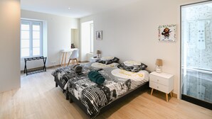 A modern bedroom with a large bed, a desk, and a chair. - La Maison des Ours - proche plage de Courseulles (Courseulles-sur-Mer)