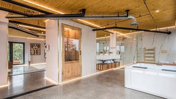 A modern interior with a wooden ceiling, a spa area with a wooden door, and a large white reception desk.