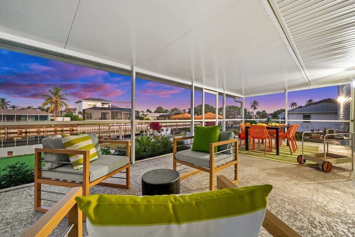 A rooftop terrace with seating, a dining area, and a view of the cityscape.