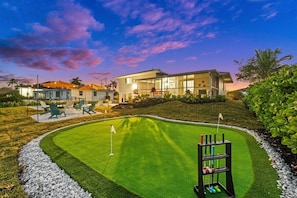 Ein Golfplatz mit Putting Green, Fahne und Loch.