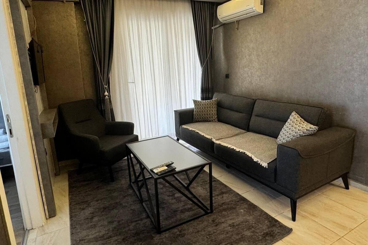 A modern living room with a sofa, a coffee table, and a TV.
