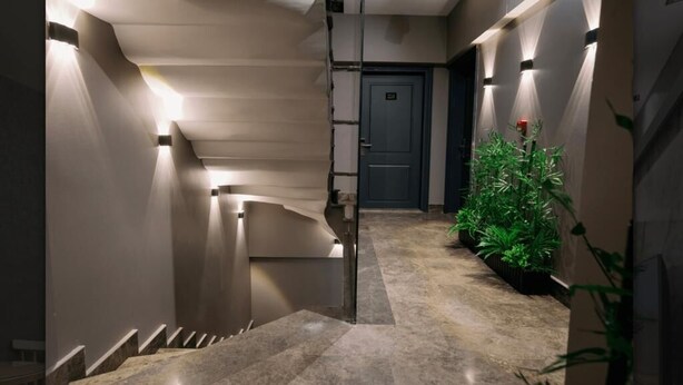 Een modern interieur met een trap, een deur en een plant.