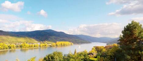Vista panorámica de un lago rodeado de colinas y un pequeño pueblo.