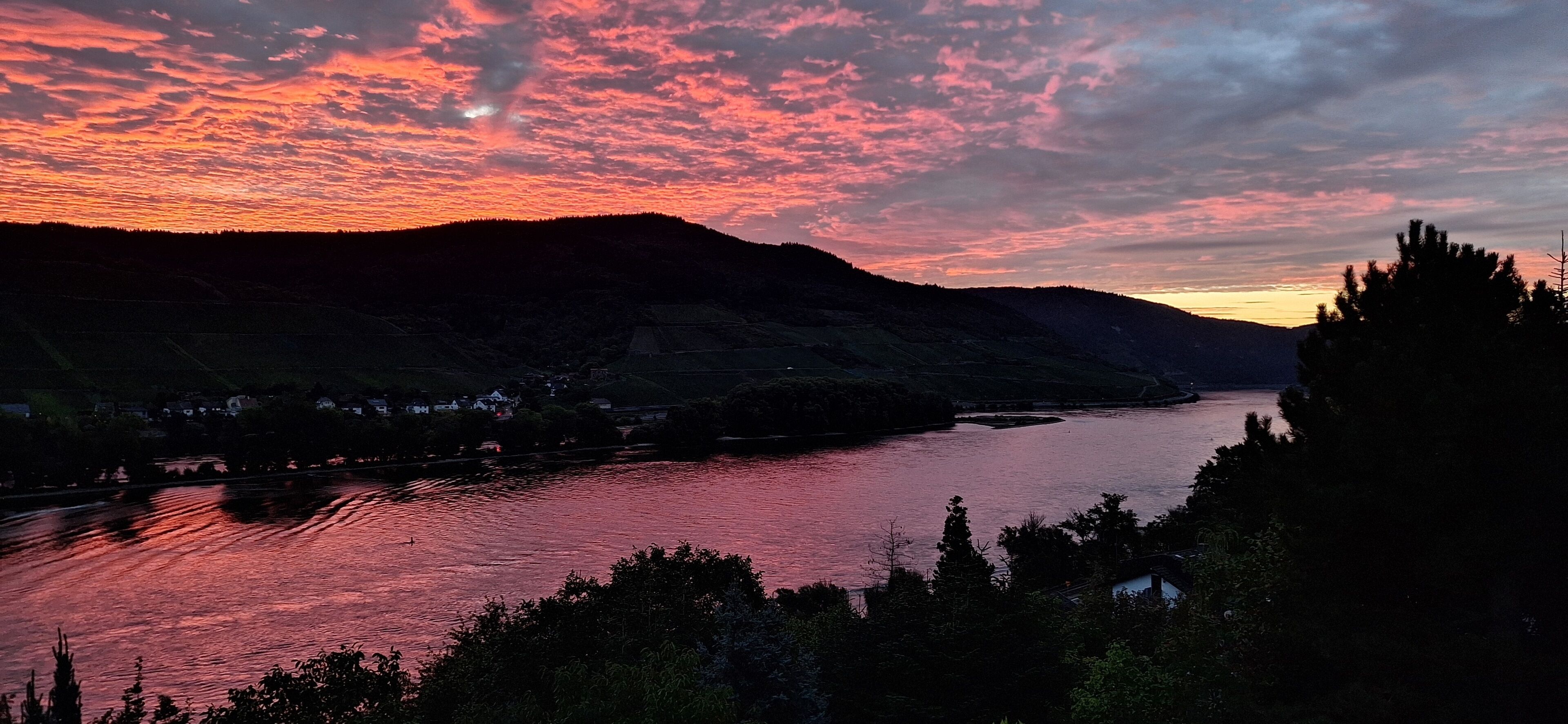 A river flowing through a valley with a sunset sky.